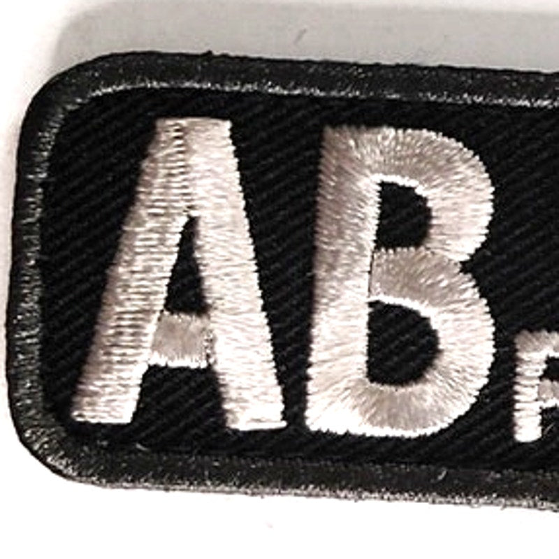 AB+ POS Blood Type Patch White on Black w/ Gray Border 2" × 1" Hook‑Back